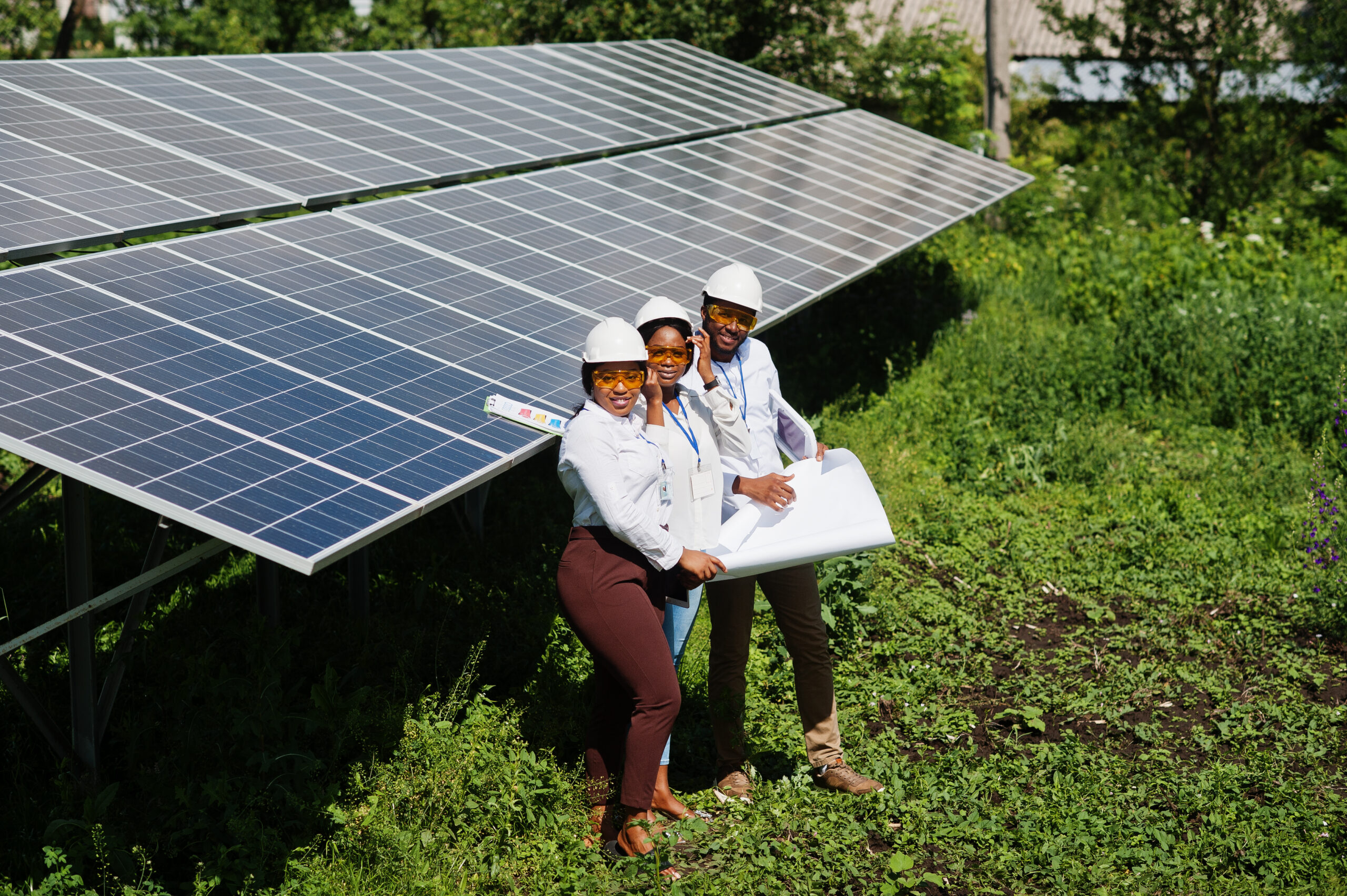 African american technician checks the maintenance of the solar panels. Group of three black engineers meeting at solar station.
